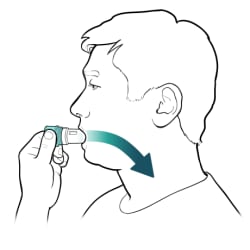 Person holding inhaler with lips closed on mouthpiece, breathing in.