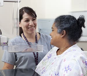 Technician helping person during mammogram
